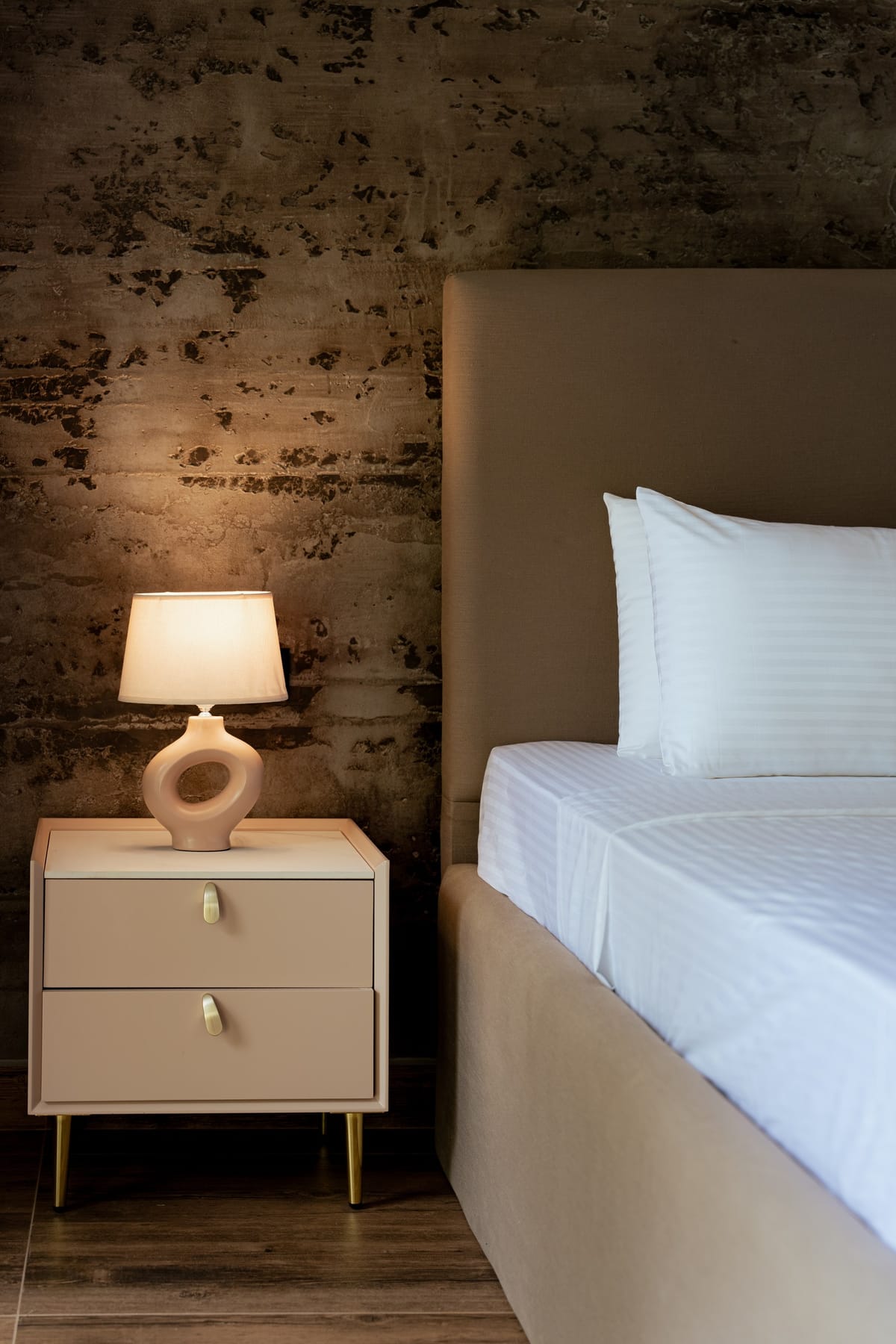 Pool View Room 1, bedside table and stone wall