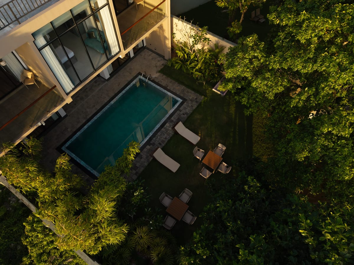 The pool, its sun loungers and garden tables seen from above