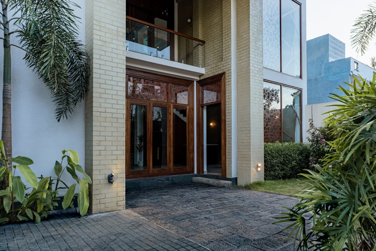 The hotel entrance, carved wooden doors and pale brick façade